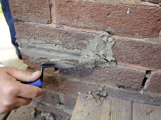 Comment réparer le mortier sur les murs de briques